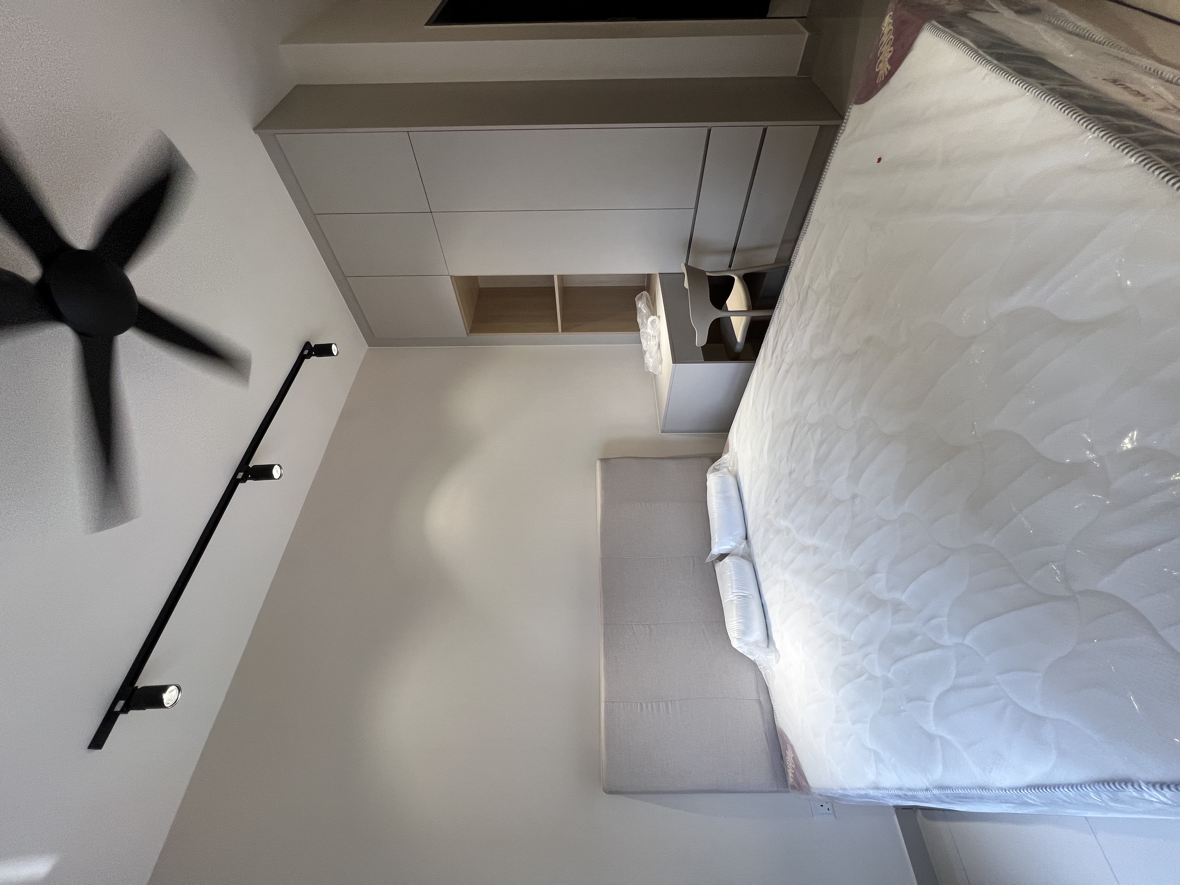Minimalist bedroom — track lighting, wardrobe, clean design