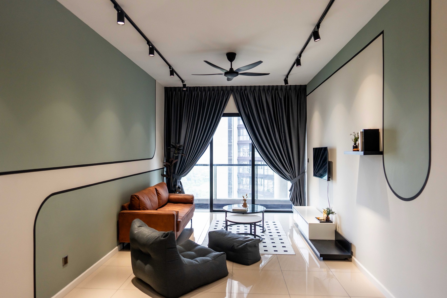Duta Park Residence living room renovation — green feature wall, leather sofa, track lighting