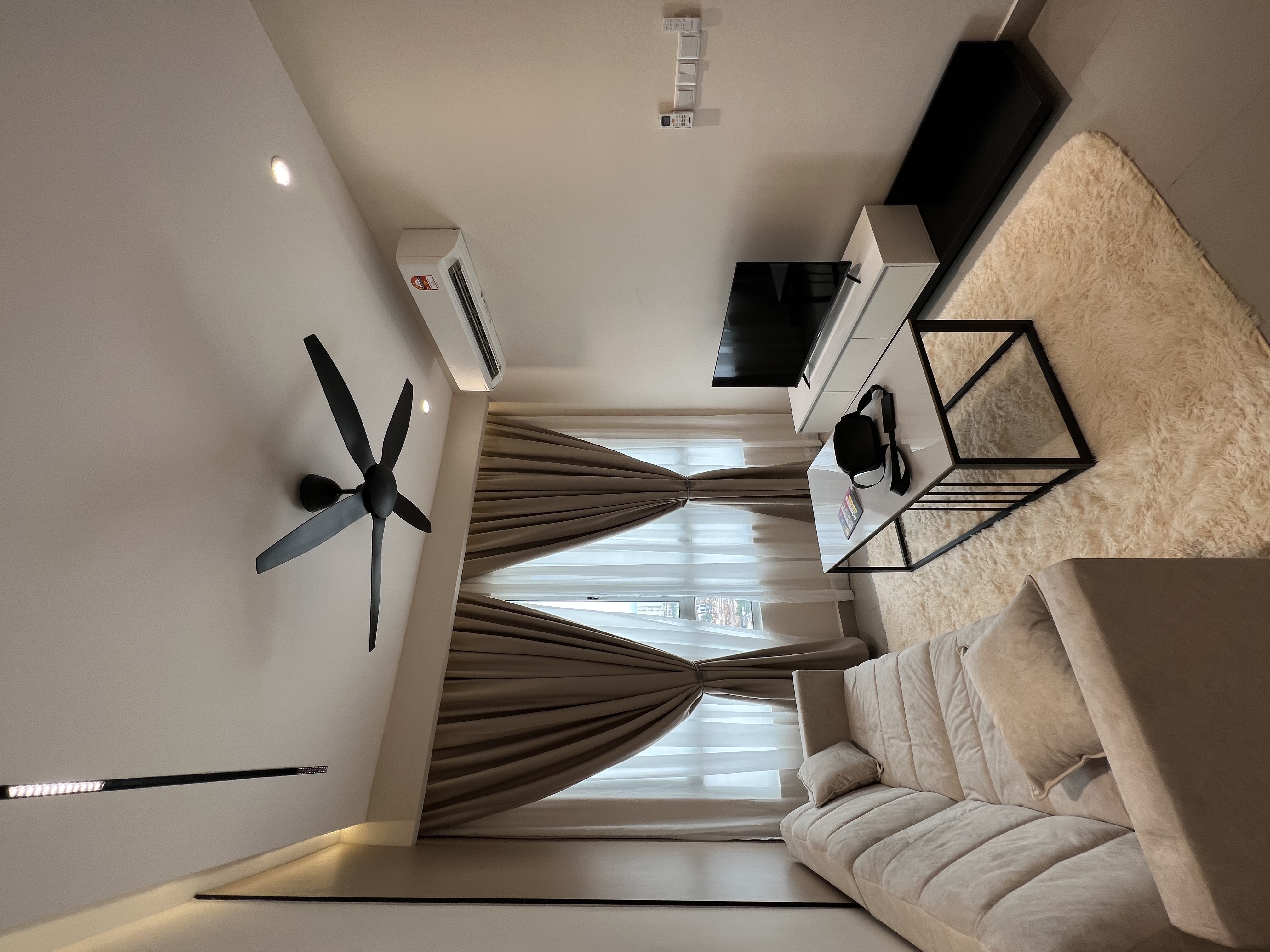 Klang Valley condo living room — beige tones, fan, curtain, aircon